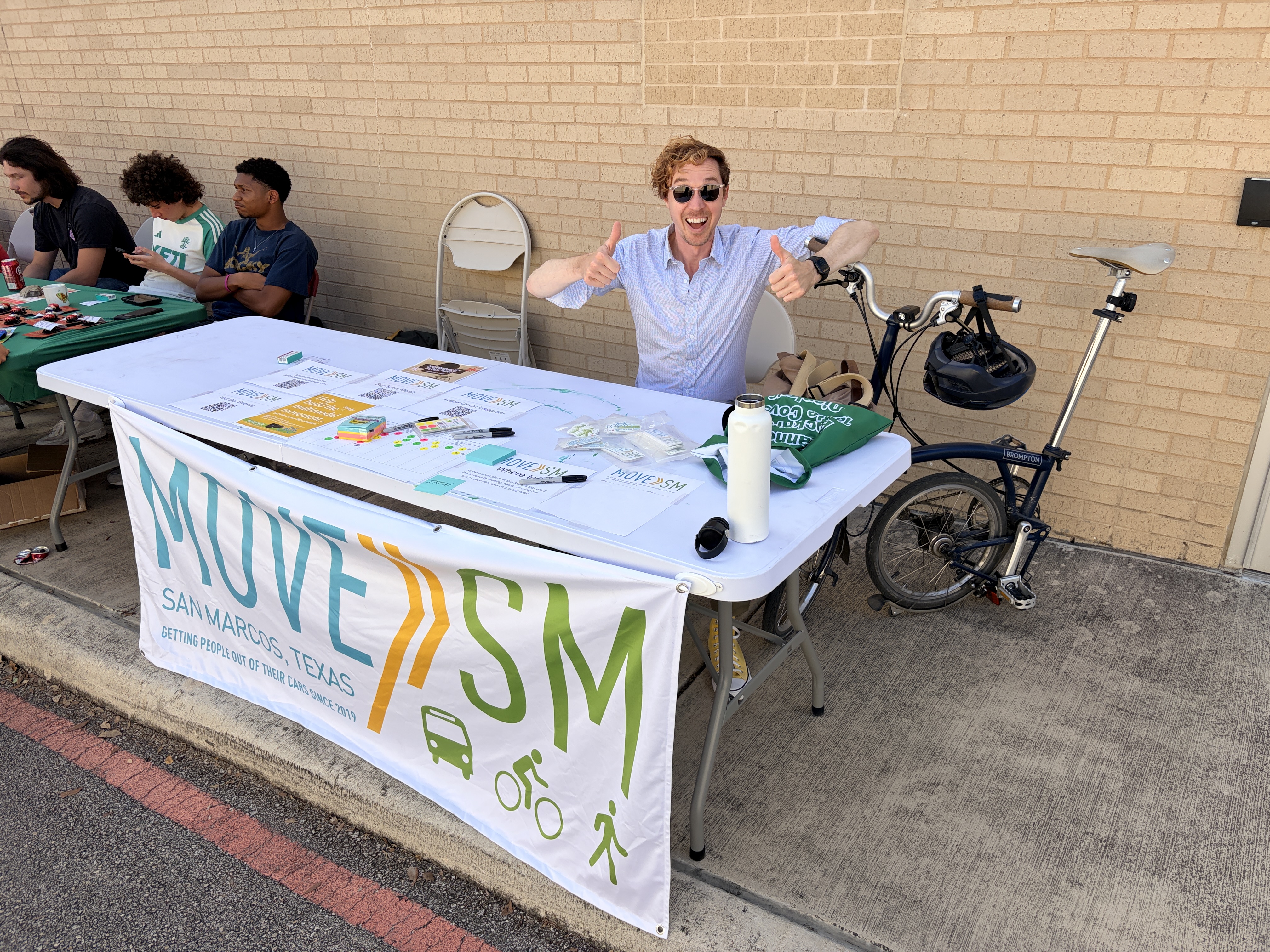 Person at an outreach table with "MoveSM" on the front.